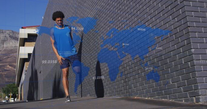 Vertical video: Adult male walking toward camera, shifting into side lunges, warming up by map wall