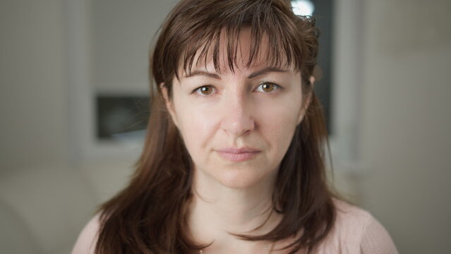 Close up portrait of serious woman with brown hair looking, have fun and enjoy