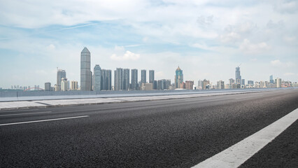 Fototapeta premium Empty Road Leading to Modern City Skyline