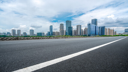 Asphalt Road Leading to Modern City Skyline