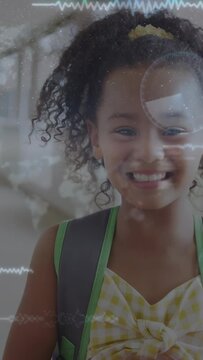 Vertical video: Girl smiling and lifting red notebook in hall, frames sparking waveforms for school