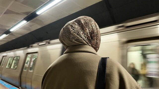 Woman waits for train at city subway station