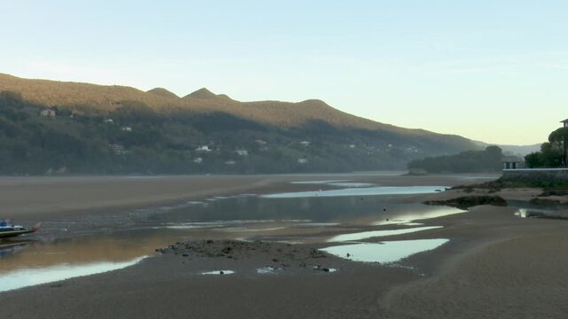 Scenic view of Urdaibai wetland in Bizkaia, a biosphere reserve and key migratory bird habitat. Natural marsh landscape with tidal waters, vegetation, and peaceful environmental biodiversity.