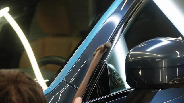 PDR. Process of paintless dent repair on car body. The mechanic at the auto shop with tools to repair dents in car body. Body repair. A specialist repairs a dent on the car body without painting.