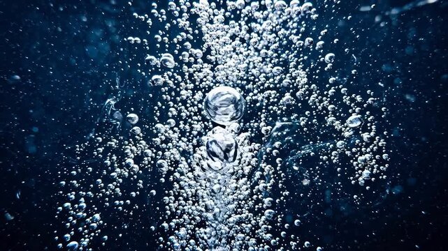 Underwater macro shot of smooth river stones and swirling bubbles with fast shutter speed freezing the abstract liquid motion beautifully.