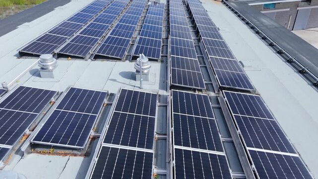 Drone aerial footage: solar panel power plant on roof solar on rooftop of public pool in Halifax produce clean electricity. Nova Scotia Canada renewable energy initiative, clear summer sky view 4K.
