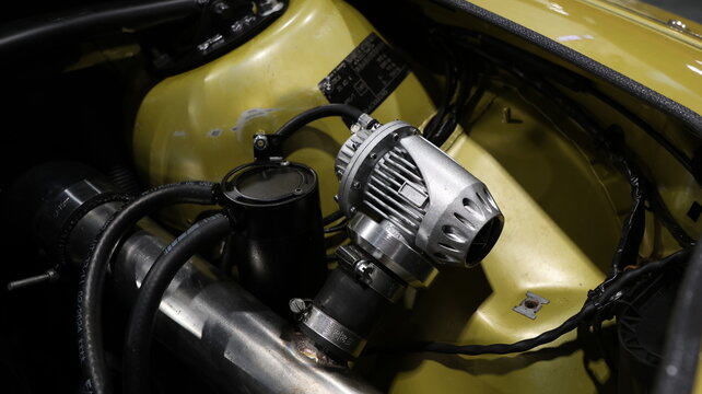 Close up of a performance blow off valve and oil catch can in a modified engine bay