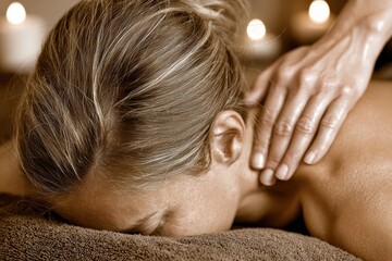 Fototapeta premium A relaxing neck massage in a dimly lit spa environment, with a woman receiving treatment to relieve tension and promote wellness, creating a sense of calm and serenity.