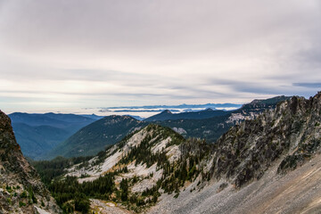 Fototapeta premium Misty peaks rise above rugged, rocky slopes