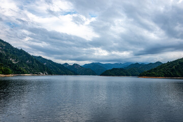 Fototapeta premium 新潟県奥只見湖の雄大な湖面、ドラマチックな曇り空と山並み