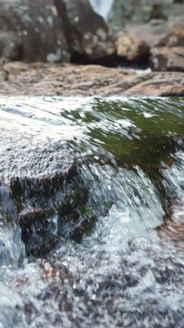 Scenic view of natural waterfall in lush green Norwegian forest. Flowing water, rocky stream, and peaceful surroundings promote eco tourism, relaxation, and nature-inspired travel lifestyle.