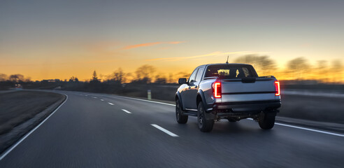 Pickup truck driving on open highway at sunset with motion blur. Pickup road travel. © puhimec