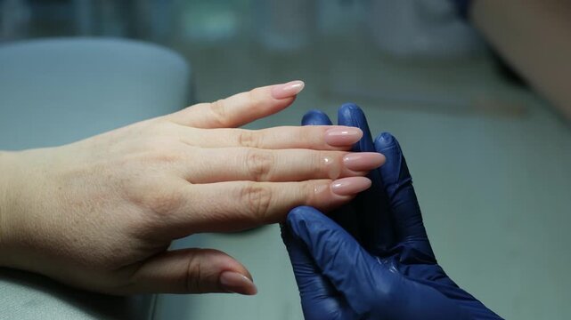 Careful hand care: pushing back cuticles and applying healing polish to strengthen brittle nails. High quality 4k footage