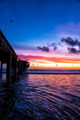 Fototapeta premium Long pier stretches into calm water at twilight