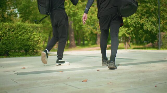 two white men walking with skateboard on tiled pavement, closeup of feet and wheels, stride synch, black outfits, urban campus commute vibe, textured concrete and scattered leaves