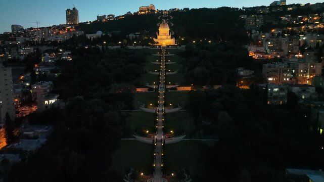Aerial night view of Haifa with the Baha'i Gardens, German Colony, and the illuminated city port, Israel