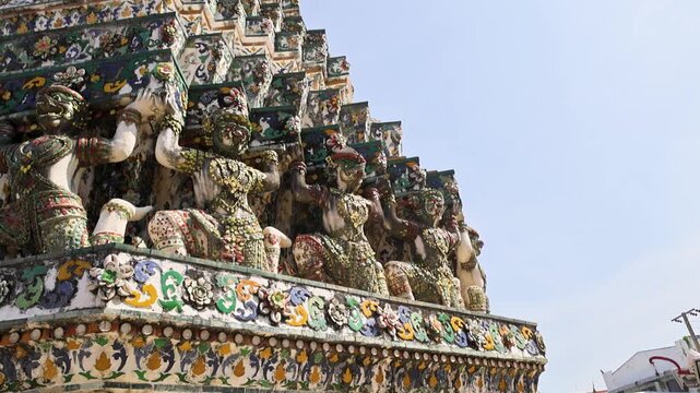 Intricate guardian group atop temple base with painted details Wat Arun