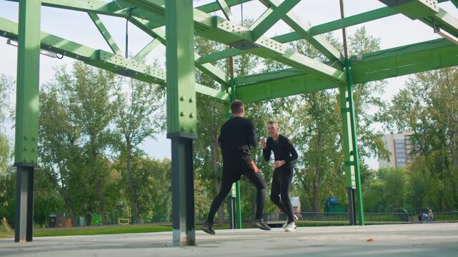 green pavilion boxing drills with white men practicing combinations and footwork around metal columns, low angle framing, autumn foliage backdrop, focused mentorship and teamwork during outdoor