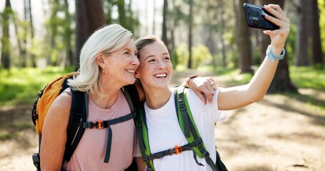 Obraz premium Nature, hiking and women with smile for selfie, document memory and bonding for profile picture. Outdoor, senior mother and daughter with photography for social media, fitness experience and wellness