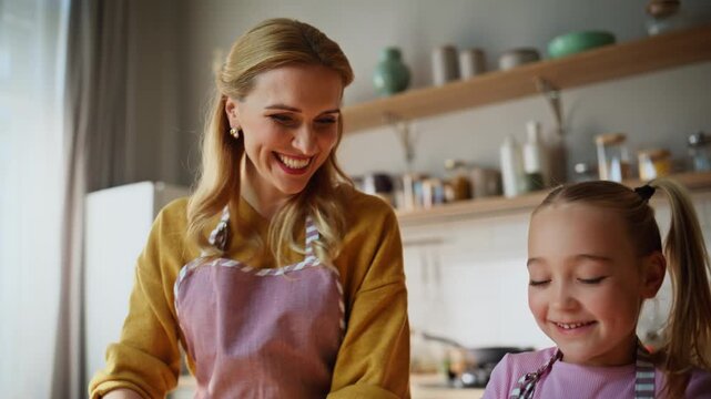 Mom child kneading dough on table closeup. Cute family preparing cookies pastry