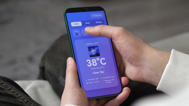 Man scrolling weather app showing 38 degree scorching sun and heatwave alerts. Perfect for climate change news, summer lifestyle, and global warming reports. High-quality 4k footage of smartphone
