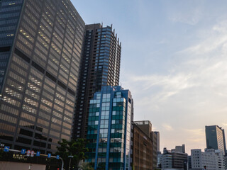 Fototapeta premium 見上げる夕暮れのオフィス街と窓の明かり