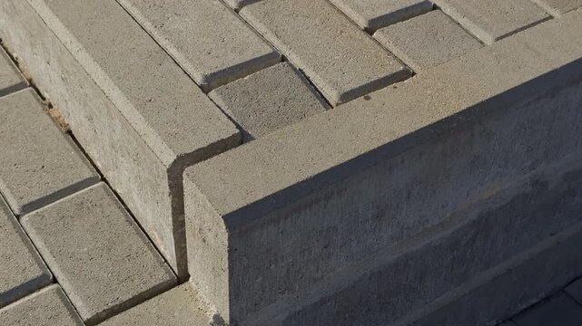 Factoryfinished concrete pavers arranged uniformly. Closeup of industrial precast concrete tile pattern with consistent texture