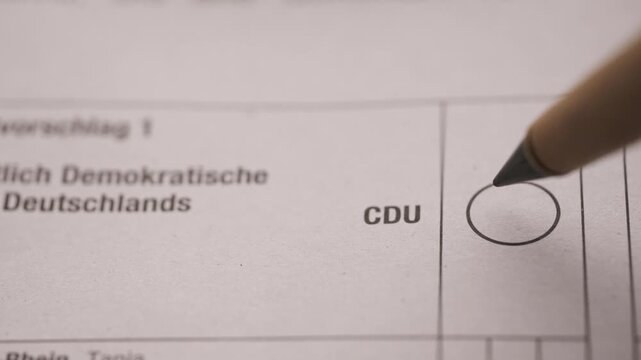 Voter marking cross in circle CDU party on German ballot paper, democratic elections in Germany, political voting process, federal election, citizen participation in politics, social democratic choice