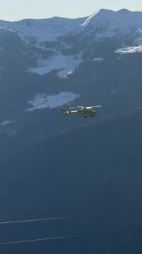 a rescue helicopter flies over the mountains