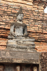 Fototapeta premium statue of buddha in a ruined ancient buddhist temple (wat mahathat) in sukhothai in thailand 