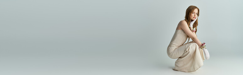 Young woman in elegant dress poses gracefully amid vibrant spring flowers