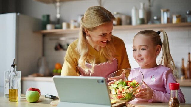 Mom child watching tablet having videochat together in cozy kitchen closeup