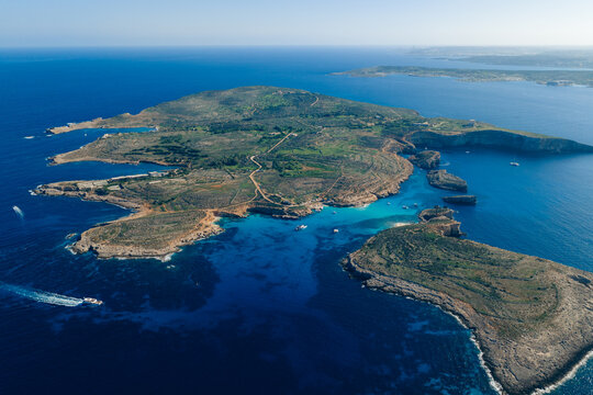 Aerial view of the stunning Blue Lagoon's turquoise waters embracing the rugged coastline of Comino Island, a Maltese paradise where azure meets earth, Blue Lagoon, Malta.