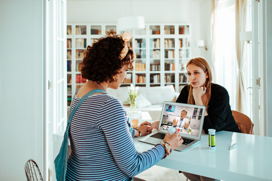 Two women consult a doctor via telemedicine at home