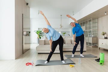 Naklejka premium Fitness training. Senior mature healthy fit couple doing sports exercise at home. Mid age husband wife have training workout. Health care healthy lifestyle. Workout rehabilitation for old man woman