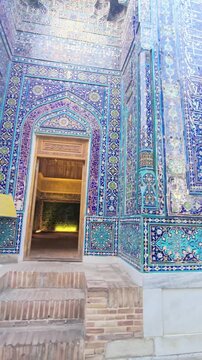 Three mausoleums in Shah-i-Zinda necropolis in golden light. Circling video stunning turquoise, blue, geometric mosaics, arched portals, Timurid Islamic architecture heritage. Samarkand, Uzbekistan.