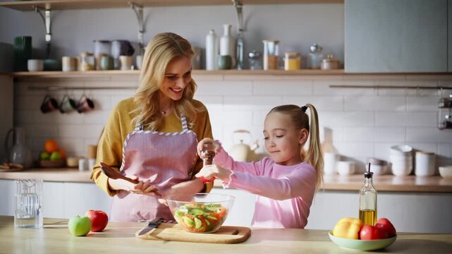 Cute kid adding oil cooking with mom kitchen closeup. Family mixing ingredients