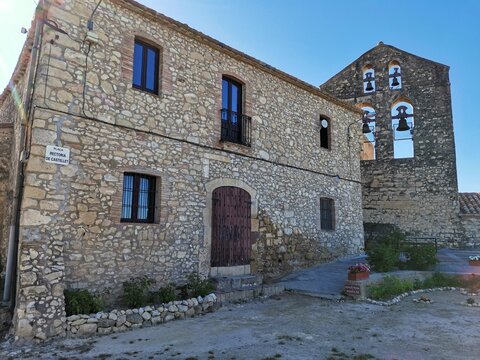 Rustic stone house and old church bell tower in Castellet village, Spain.
