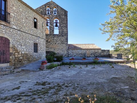 Historic church bell gable and stone plaza in Castellet i la Gornal, Spain.