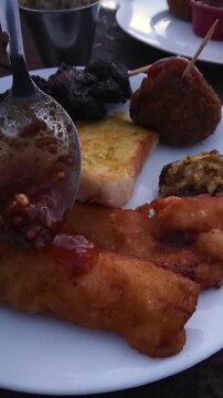 Adding Peanut Sauce Sambal on Fried Plantain. Snacks on Plate during Iftar in Ramadan
