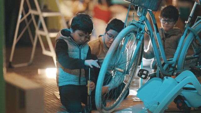 Young boy pumping up bicycle tire with friends