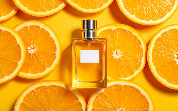 rodajas de naranjas frutas citricos con un envase de perfume importado sobre ellas. Estilo publicitario. Luz de estudio. Vista superior