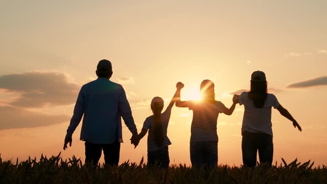 Happy family, parents kids, raising their hands sunset. Teamwork group people standing with their hands raised in wheat field. Group prayer to sun. Family business. Parents mom dad child holding hands