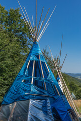  Damaged Wigwam Covered with Blue Plastic on Carpathian Meadow © Alla