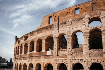 Fototapeta premium Close perspective of Colosseum arches and ancient stone facade in Rome