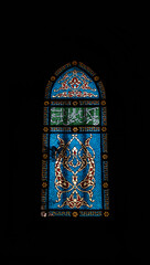 Ornamental stained glass window with Arabic calligraphy and blue patterns