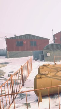 A research station stands boldly against the chilling backdrop of snow and rocky terrain.