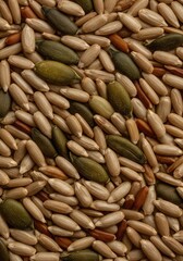 Naklejka premium A close-up, highly detailed pattern of mixed organic seeds, creating a natural, beige, and brown color palette for creative design work, ingredient, healthy, gold