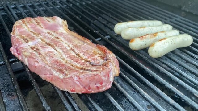 Steak und Bratw&uuml;rste auf dem Gasgrill, saftiges Fleisch &uuml;ber Hitze, BBQ-Genuss im Freien, rustikale Grillaufnahme als Video-Content mit Copyspace