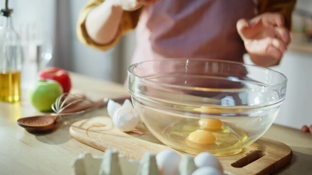 Woman hand taking egg breaking glass bowl closeup. Mother daughter cooking pie